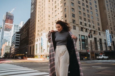 woman in black coat standing on pedestrian lane during daytime